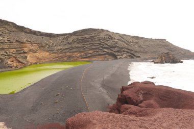 Lanzarote, El Golfo 'nun siyah kumsalındaki eşsiz yeşil göl. Yosun zengini suyla dolu volkanik bir krater. Yüksek kalite fotoğraf