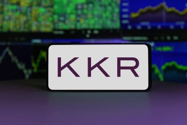 KKR logo displayed on a smartphone screen with stock market charts in the background. January 2, 2025 clipart