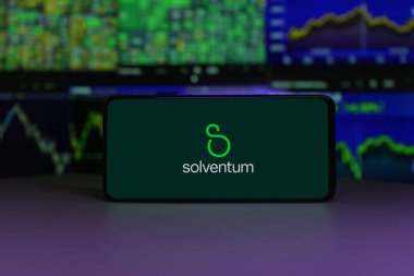 Solventum logosu, arka planda borsa çizelgeleri olan bir akıllı telefon ekranında görüntülendi. 2 Ocak 2025