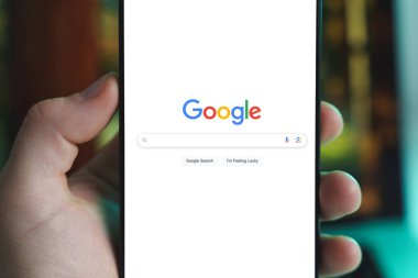 Google arama web sayfasını gösteren akıllı telefonu tutan bir el. 15 Ocak 2025