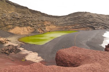 Lanzarote, El Golfo 'nun siyah kumsalındaki eşsiz yeşil göl. Yosun zengini suyla dolu volkanik bir krater. Yüksek kalite fotoğraf