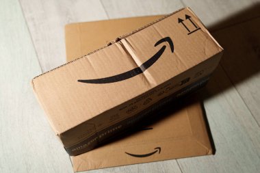 Amazon karton kaplama tarafı yukarıdan ahşap parke zeminde görünüyor. Amazon, dünya çapında bir elektronik ticaret şirketi dağıtımıdır. 3 Şubat 2025