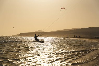 Fuerteventura 'da gün batımında kumlu bir sahilde uçurtma sörfü. Yüksek kalite fotoğraf