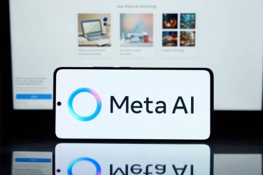 Akıllı telefonda Meta AI logosu görülüyor. Arka plandaki bilgisayar ekranı yapay zeka arayüzünü gösteriyor. Teknik kavram 2 Mart 2025