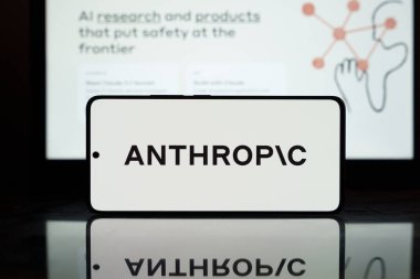 Antropik yapay zeka logosu arka planda bulanık bir akıllı telefon ekranında görüntülenmiş. 2 Mart 2025
