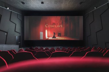 Ekranda Conclave filmi olan bir sinema salonu. Sinema, eğlence, yeni serbest bırakma kavramları. Yüksek kalite fotoğraf. 13 Şubat 2025