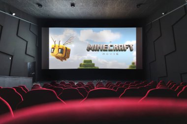 Minecraft sinema ekranında Minecraft Movie posteri gösteriliyor, boş kırmızı sinema koltuklarından izleniyor. 5 Nisan 2025