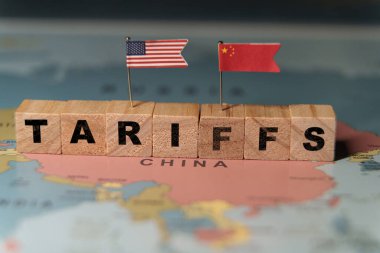 Tahta bloklar, TARIFFS sözcüğünü oluşturarak Çin üzerinde bir dünya haritasına yerleştirilmiş, ticaret politikasını temsil eden küçük ABD ve Çin bayrakları. Yüksek kalite fotoğraf