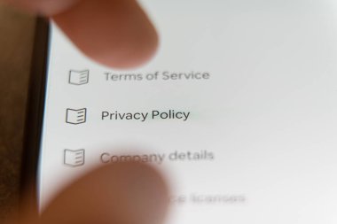 Bir ayarlar menüsünde Gizlilik Politikası seçeneğini tıklamak üzere olan bir akıllı telefon ekranının yakın plan görüntüsü. Yüksek kalite fotoğraf