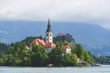 Slovenya 'daki rüya gibi Bled Gölü manzarası çiçek açan kestane ağaçları adanın kilisesini yemyeşil Alp tepelerine karşı çerçeveliyor. Yüksek kalite fotoğraf