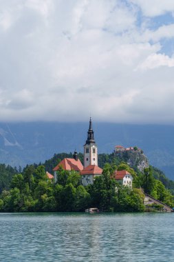 Slovenya 'da bulutların altında doğa ile çevrili Bled Gölü' ndeki güzel ada kilisesi. Yüksek kalite fotoğraf
