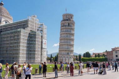 Tuscany, İtalya 'da güneşli bir günde Eğik Pisa Kulesi yakınlarında yürüyen turistler. 15 Mayıs 2025