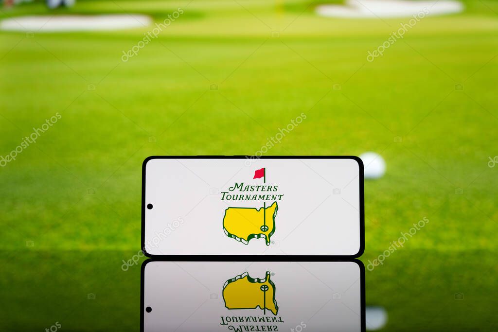 Smartphone displaying Masters Tournament logo with a blurred golf ball and green field in the background. Professional golf championship concept. March 17, 2025