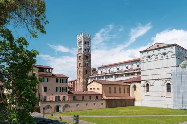 Lucca, İtalya 'daki tarihi katedral ve çan kulesi manzarası, geleneksel binalar ve mavi gökyüzü. Yüksek kalite fotoğraf