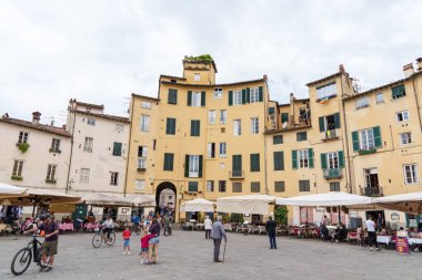 İnsanlar Lucca, İtalya 'da ünlü bir meydan olan Piazza dell' Anfiteatro 'da yürüyüp dinleniyorlar. 17 Mayıs 2025