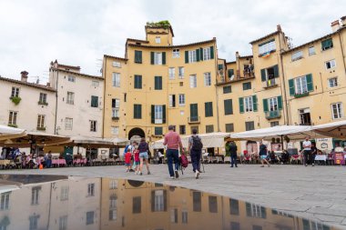 İnsanlar Lucca, İtalya 'da ünlü bir meydan olan Piazza dell' Anfiteatro 'da yürüyüp dinleniyorlar. 17 Mayıs 2025