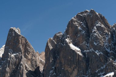 Close-up view of sharp snowy peaks in the Dolomites, Italy, under clear blue sky. High quality photo