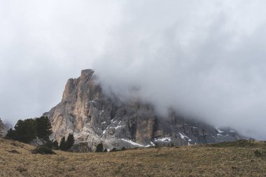 Sassolungo dağının dramatik manzarası kısmen bulutlarla kaplı, kayalık uçurumlar ve İtalya 'nın Dolomitler kentindeki otlak otlaklarıyla. Yüksek kalite fotoğraf