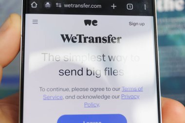 Dosya paylaşım arayüzü ve servis iletisinin şartları ile WeTransfer ana sayfasını gösteren akıllı telefon ekranı. 18 Temmuz 2025