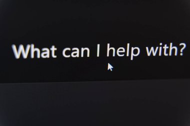 Yapay zeka asistanının üzerinde gezinen fare imleci koyu dijital bir arayüzde ne yardımcı olabilirim diye sorar. Yüksek kalite fotoğraf