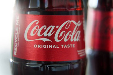 Cam Coca-Cola şişesinin yakın çekimi orijinal tat kırmızı etiketini yoğunlaştırma ve geri dönüşümlü mesajla gösteriyor. Yüksek kalite fotoğraf