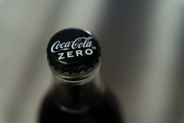 Siyah kapaklı, beyaz logolu ve yoğunlaşma damlacıklı cam Coca-Cola Zero kapağı. Yüksek kalite fotoğraf