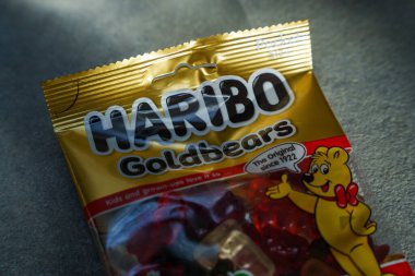 Haribo Goldbear şekerlemelerinden oluşan bir paket gri bir yüzey üzerinde altın rengi yeniden mühürlenebilir bir çanta. Yüksek kalite fotoğraf