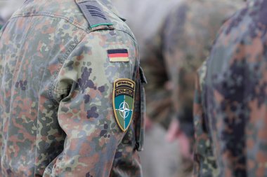 Flecktarn kamuflaj üniformalı, NATO OTAN omuz bandı ve Alman bayrağı rozeti takmış Alman askeri. Yüksek kalite fotoğraf