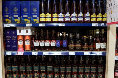 Süpermarket raflarında sergilenen Metaxa da dahil olmak üzere çeşitli alkol şişeleri. Yüksek kalite fotoğraf