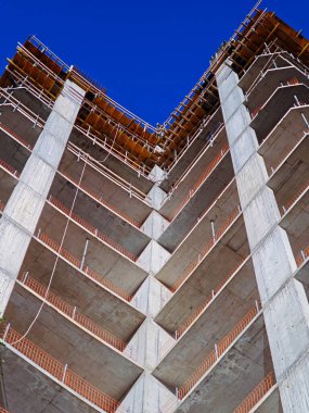  Çıplak beton zemin ve parlak turuncu güvenlik raylarıyla inşa edilmiş yeni bir binanın balkonları. Yüksek kalite fotoğraf