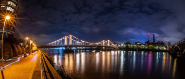 Londra, İngiltere 'de gece vakti Chelsea Köprüsü ve Battersea Parkı manzarası