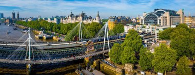 Londra 'daki Charing Cross İstasyonu' nun insansız hava aracı görüntüsü modern kemerli tasarımı, tren rayları ve kentsel konumu vurguluyor. Ulaşım, seyahat ve altyapı temaları için harika