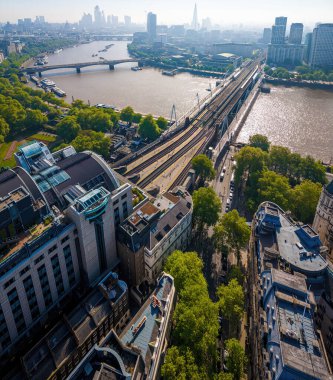 Londra 'daki Charing Cross İstasyonu' nun insansız hava aracı görüntüsü modern kemerli tasarımı, tren rayları ve kentsel konumu vurguluyor. Ulaşım, seyahat ve altyapı temaları için harika