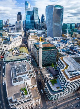 Londra 'nın merkezindeki anıtın dinamik hava görüntüsü, tarihi Büyük Yangın Anıtı ile modern cam kuleleri birleştiriyor. Turizm, iş ve emlak temaları için mükemmel