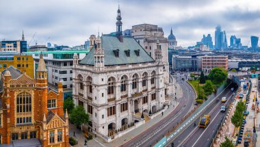 Blackfriars Köprüsü, işlek Londra yolları ve arka planda modern ufuk çizgisi ile süslü tarihi bina manzarası; seyahat, mimari ve kentsel planlama için ideal