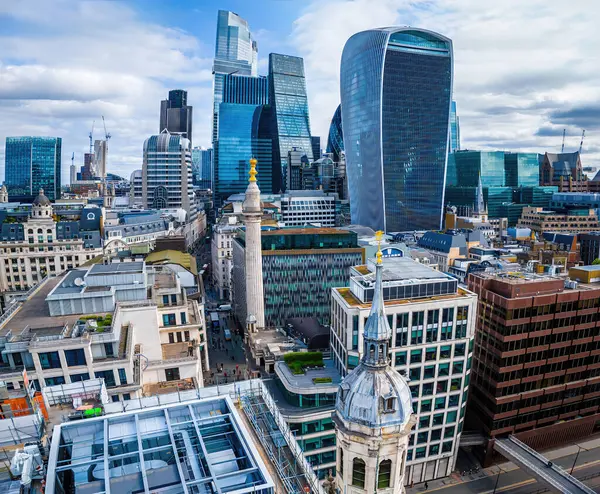 Londra 'nın merkezindeki anıtın dinamik hava görüntüsü, tarihi Büyük Yangın Anıtı ile modern cam kuleleri birleştiriyor. Turizm, iş ve emlak temaları için mükemmel