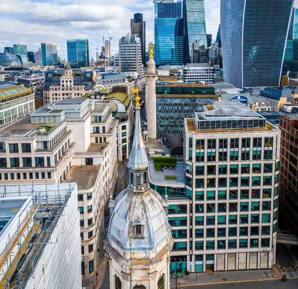 Londra 'nın merkezindeki anıtın dinamik hava görüntüsü, tarihi Büyük Yangın Anıtı ile modern cam kuleleri birleştiriyor. Turizm, iş ve emlak temaları için mükemmel