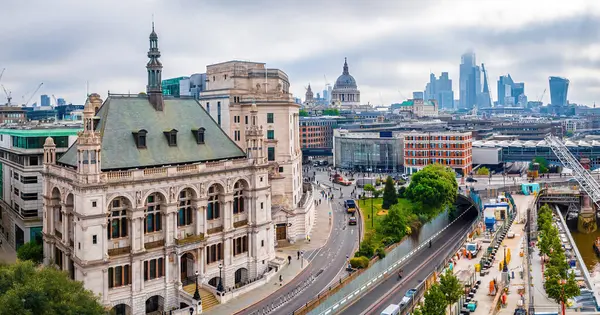 Blackfriars Köprüsü, işlek Londra yolları ve arka planda modern ufuk çizgisi ile süslü tarihi bina manzarası; seyahat, mimari ve kentsel planlama için ideal