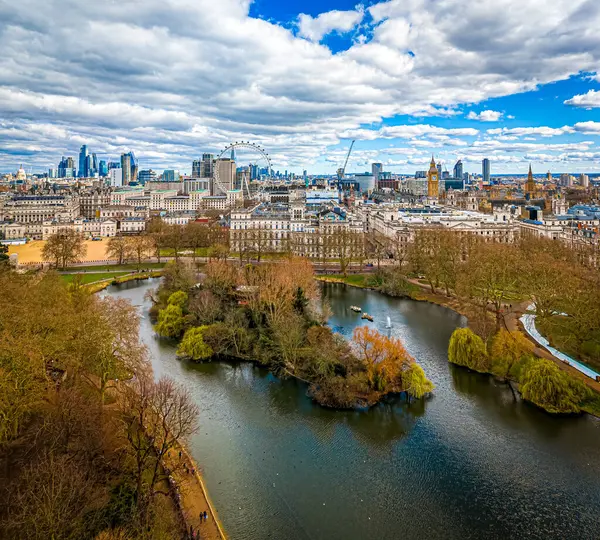 Göl, Londra 'nın merkezindeki St. James' s Park 'ın havadan görünüşü, Londra Gözü, Big Ben ve Westminster ile ikonik bir gökyüzü. Şehir simgeleri ve doğal manzaranın harika bir karışımı.