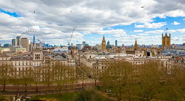 Göl, Londra 'nın merkezindeki St. James' s Park 'ın havadan görünüşü, Londra Gözü, Big Ben ve Westminster ile ikonik bir gökyüzü. Şehir simgeleri ve doğal manzaranın harika bir karışımı.