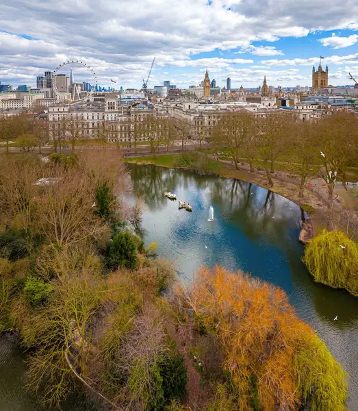 Göl, Londra 'nın merkezindeki St. James' s Park 'ın havadan görünüşü, Londra Gözü, Big Ben ve Westminster ile ikonik bir gökyüzü. Şehir simgeleri ve doğal manzaranın harika bir karışımı.