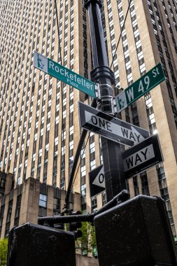 Manhattan, New York 'ta 6. Cadde ve 49. cadde için sokak tabelası olan Rockefeller Center' ın sokak manzarası. Turizm, iş, kültür ve ikonik NYC etkinliklerini temsil ediyor