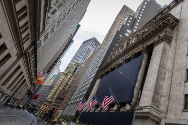 Manhattan Finansal Bölgesi Wall Street 'teki New York Borsası' nın dışı gökdelenler ve bayraklarla çevrili. Finans, ekonomi, iş, ticaret ve ikonik NYC simgesini temsil ediyor.