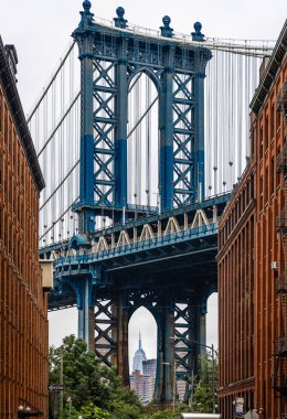 Manhattan Köprüsü 'nün ikonik görüntüsü DUMBO, Brooklyn, New York City' den, tuğla binalar tarafından çerçevelenmiş. Popüler seyahat, turizm, mimari ve kentsel yaşam tarzı fotoğrafçılık konusu