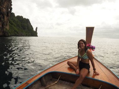 young woman in a long tail boat in thailand