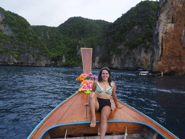 young woman in a long tail boat in thailand