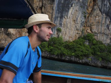 young man in a longtail boat in thailand