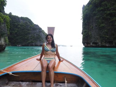 young woman in a long tail boat in thailand