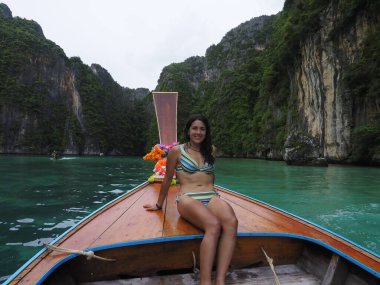 young woman in a long tail boat in thailand