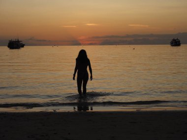 silhouette of a young woman in a beach of koh tao thailand